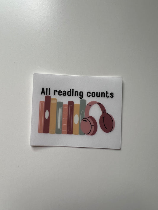 A clear vinyl sticker with a colorful row of books and pink toned headphones that says “all reading counts” above the images.