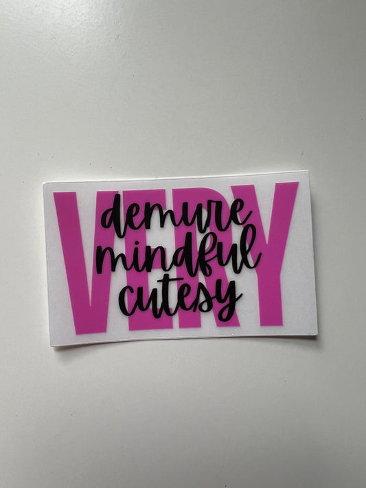 Clear background sticker with hot pink font that says VERY and black font across it that says demure, mindful, cutesy. To make the saying “very demure, very mindful, very cutesy.”